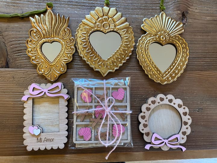 Gold tin milagro heart mirrors and small wooden frames painted “Mi Amor.”